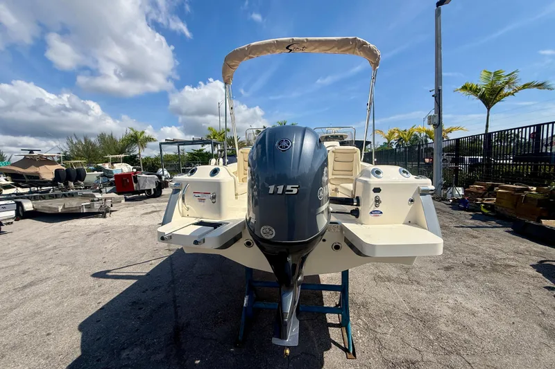 Slide: The Image of 2026 Scout 188 Sport Dorado boat with Yamaha 115 engine, parked outdoors. - 2