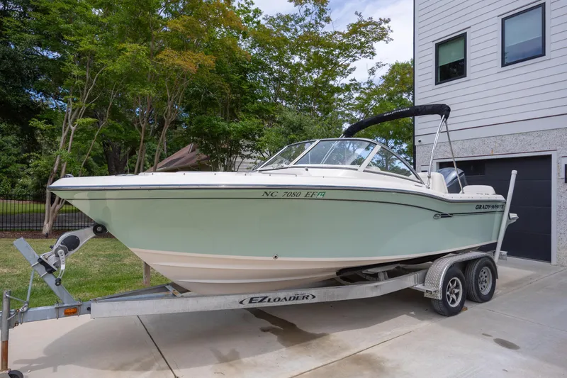 The Image of 2018 Grady-White Freedom 215 boat on trailer, parked beside modern house. - 0