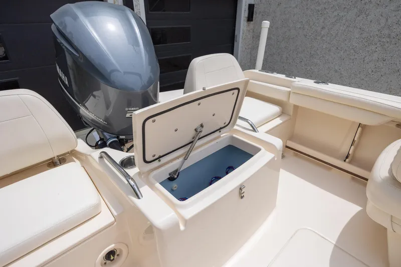 Slide: The Image of 2018 Grady-White Freedom 215 boat with open storage compartment and Yamaha outboard motor. - 12