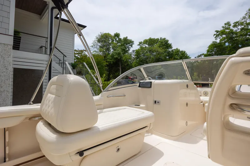 Slide: The Image of 2018 Grady-White Freedom 215 boat interior with cream seating and dashboard, outdoors. - 13