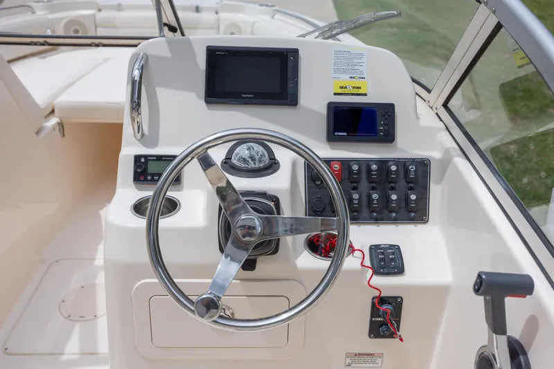 Slide: The Image of 2018 Grady-White Freedom 215 boat dashboard with steering wheel and navigation controls. - 17