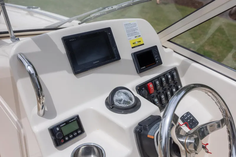 Slide: The Image of 2018 Grady-White Freedom 215 boat dashboard with steering wheel and navigation controls. - 18
