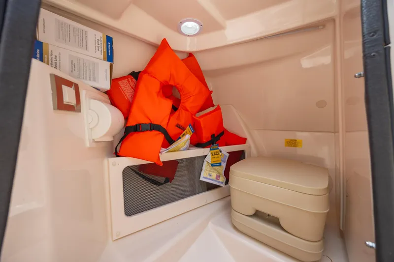 Slide: The Image of Interior of 2018 Grady-White Freedom 215 boat with life jackets and portable toilet. - 20