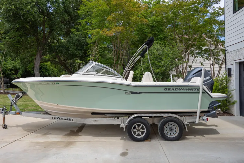 Slide: The Image of 2018 Grady-White Freedom 215 boat on trailer, parked in driveway. - 6
