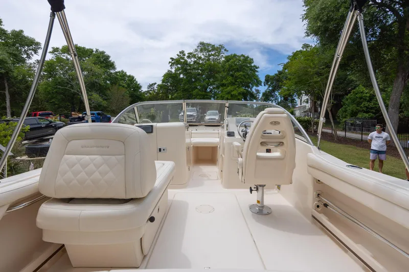 Slide: The Image of 2018 Grady-White Freedom 215 boat interior with seating and steering wheel, parked outdoors. - 8