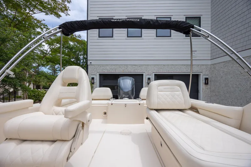 Slide: The Image of 2018 Grady-White Freedom 215 boat with luxurious seating, parked near a modern building. - 9