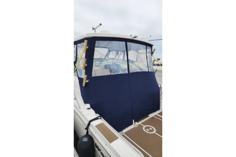 Slide: The Image of 2004 Wellcraft 290 Coastal boat with blue canvas cover at dock. - 19
