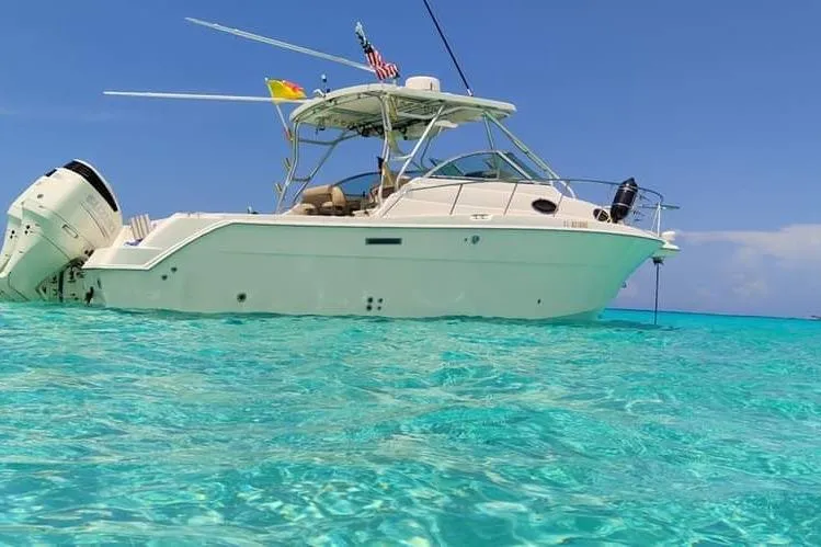 Slide: The Image of 2004 Wellcraft 290 Coastal boat on clear turquoise water under a bright blue sky. - 2