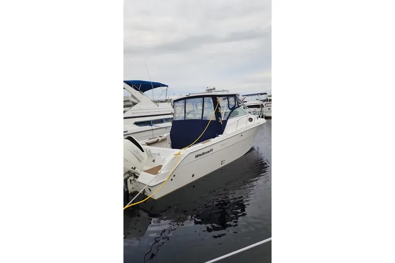 Slide: The Image of 2004 Wellcraft 290 Coastal boat docked at marina with blue canopy. - 20