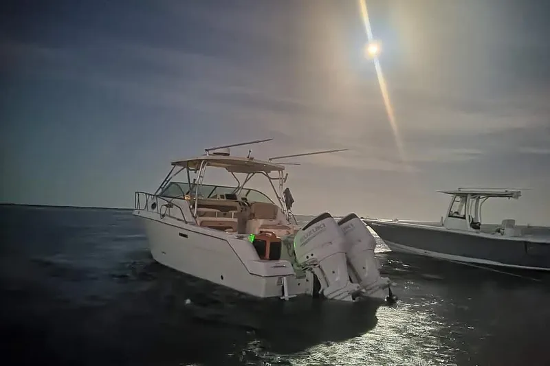 Slide: The Image of 2004 Wellcraft 290 Coastal boat on water under bright sun. - 22