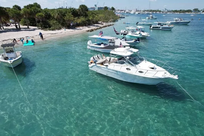 Slide: The Image of 2004 Wellcraft 290 Coastal boat anchored near a sunny beach with clear blue water. - 3