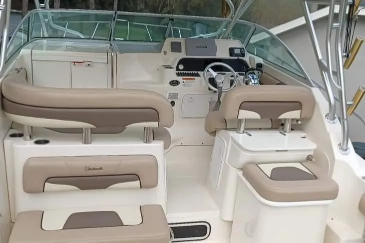 Slide: The Image of 2004 Wellcraft 290 Coastal boat interior with beige seating and modern dashboard. - 9