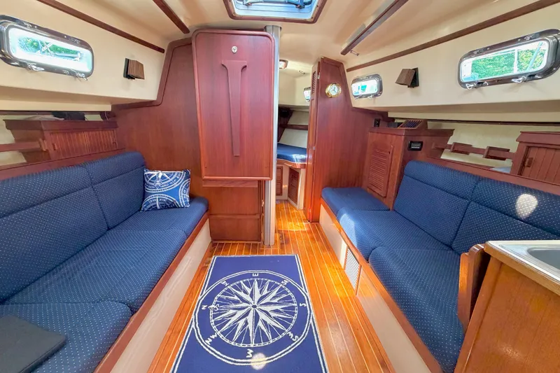Slide: The Image of Interior of a 1992 Island Packet 29 sailboat, featuring cozy seating and nautical decor. - 16