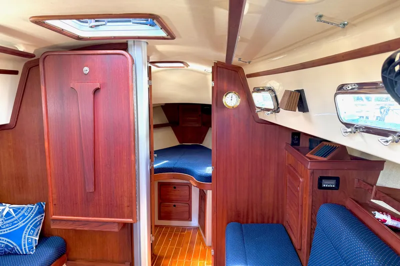 Slide: The Image of Interior of a 1992 Island Packet 29 sailboat with wood finish and blue upholstery. - 17