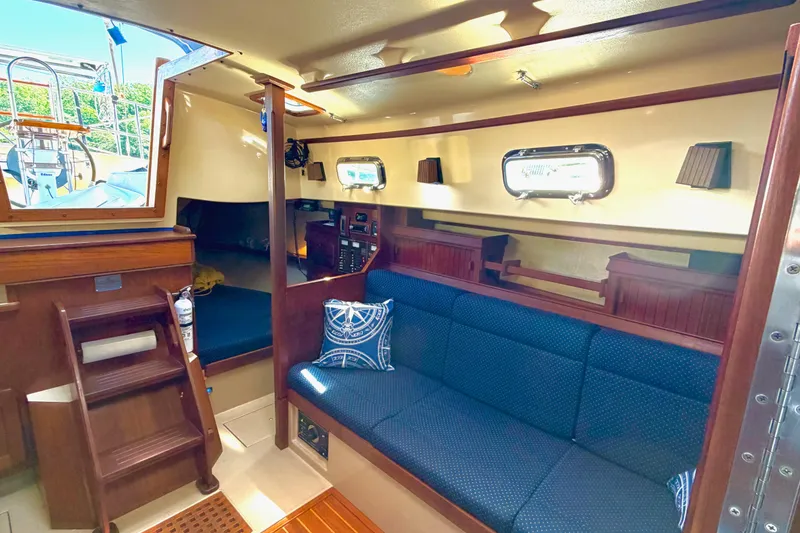 Slide: The Image of Interior of 1992 Island Packet 29 sailboat with cozy seating and wooden accents. - 24