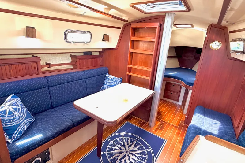 Slide: The Image of Interior of 1992 Island Packet 29 sailboat with cozy seating and wooden finishes. - 26