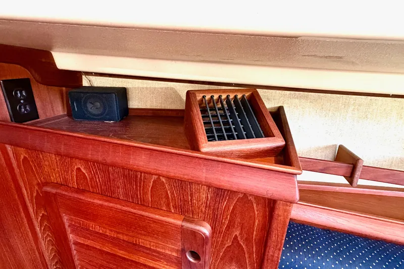 Slide: The Image of Interior of 1992 Island Packet 29 sailboat with wooden cabinetry and speaker. - 28