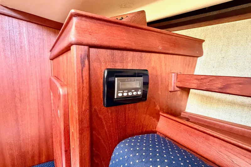 Slide: The Image of Interior of 1992 Island Packet 29 sailboat with wooden paneling and control panel. - 29