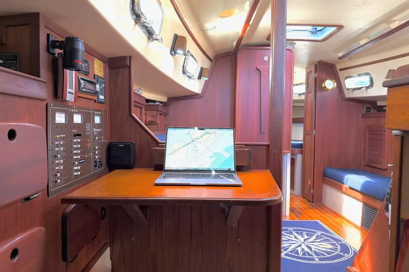 Slide: The Image of Interior of a 1992 Island Packet 29 sailboat with navigation station and laptop. - 30