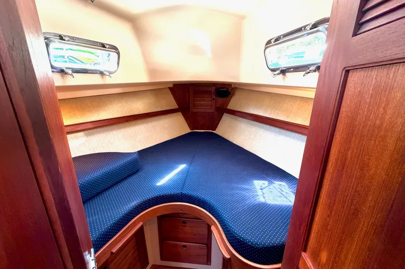 Slide: The Image of Cozy cabin interior of 1992 Island Packet 29 sailboat with wooden finish and blue bedding. - 35