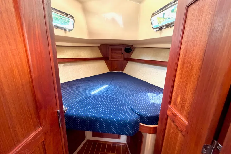 Slide: The Image of Cozy cabin interior of 1992 Island Packet 29 sailboat with blue polka dot bedding. - 38