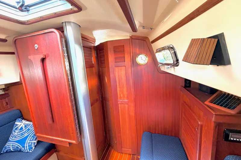 Slide: The Image of Interior of 1992 Island Packet 29 sailboat with rich wood paneling and nautical decor. - 39