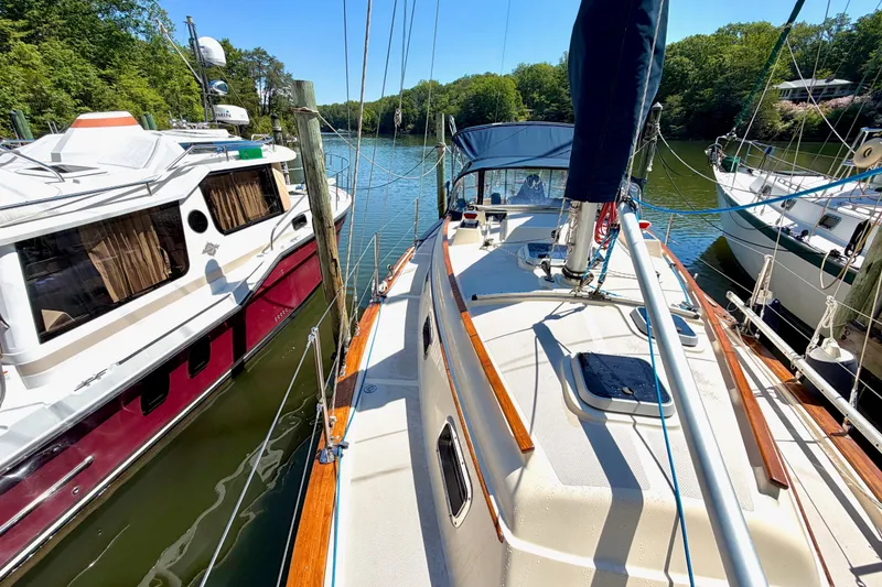 Slide: The Image of 1992 Island Packet 29 sailboat docked beside other boats on a sunny day. - 5