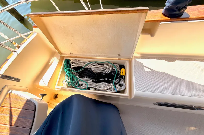 Slide: The Image of Storage compartment on a 1992 Island Packet 29 sailboat, containing coiled ropes and equipment. - 8