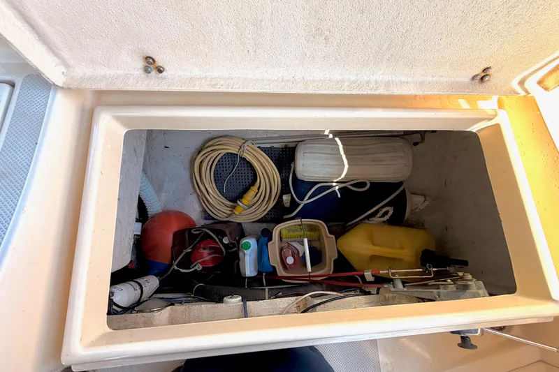 Slide: The Image of Storage compartment of a 1992 Island Packet 29 sailboat with various boating equipment. - 9