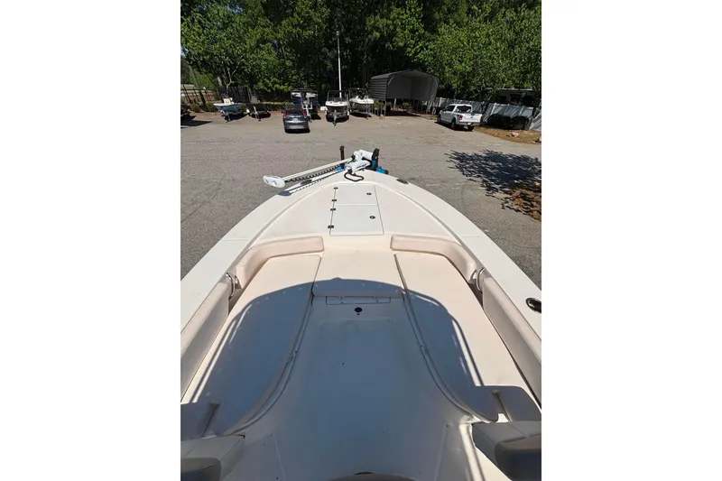 Slide: The Image of 2015 Robalo 246 Cayman boat deck view in a parking area with trees. - 11