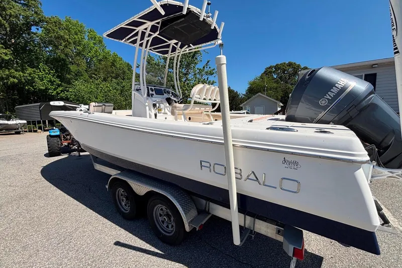 Slide: The Image of 2015 Robalo 246 Cayman boat on trailer with Yamaha engine, parked outdoors. - 4
