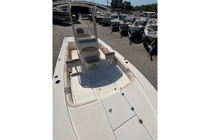 Slide: The Image of 2015 Robalo 246 Cayman boat, spacious deck, parked among other boats at a marina. - 8