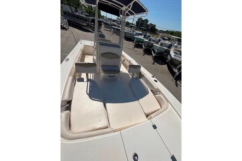 Slide: The Image of 2015 Robalo 246 Cayman boat interior with seating and console, docked outdoors. - 9