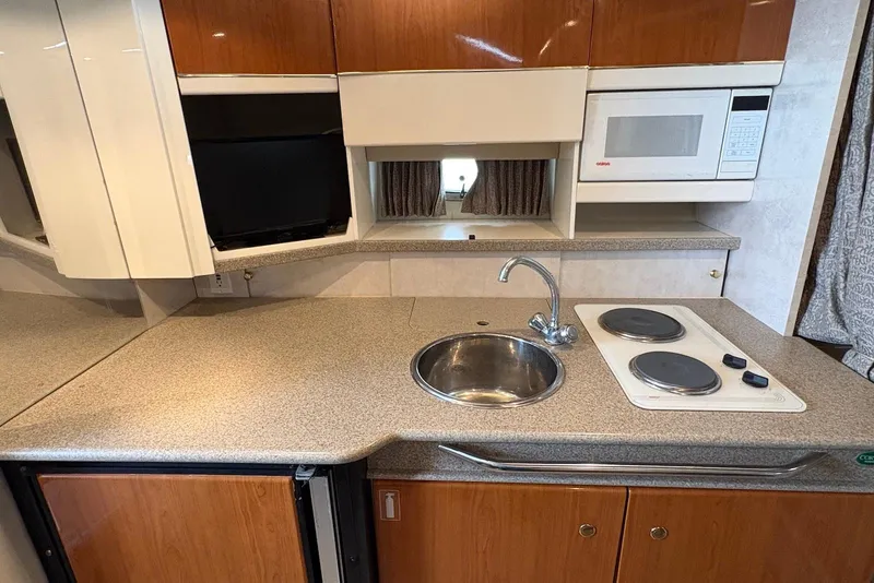 Slide: The Image of Compact kitchen in a 2001 Formula 34 Performance Cruiser with sink, stove, and microwave. - 16