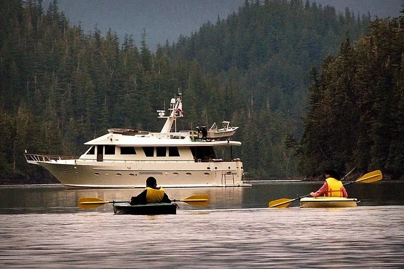 Slide: The Image of Two kayakers near a 1991 Forbes Cooper Pilothouse Motoryacht in a forested waterway. - 3