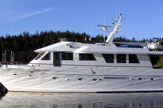 Slide: The Image of 1990 Cooper Queenship Pilothouse Motoryacht docked on calm water with forested background. - 5