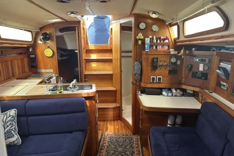 Slide: The Image of Interior of a 1994 Sabre 362 sailboat with wooden cabinetry and blue seating. - 18