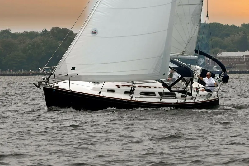 Slide: The Image of Sailing on a 1994 Sabre 362 yacht with white sails on a calm lake at sunset. - 2