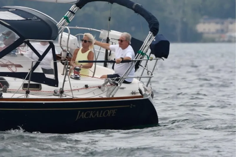 Slide: The Image of Two people sailing a 1994 Sabre 362 yacht named "Jackalope" on a calm lake. - 3