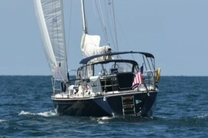 Slide: The Image of Sailing yacht Sabre 362 from 1994 navigating open waters with American flag. - 7