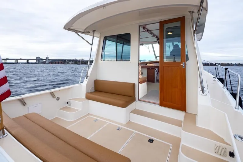 Slide: The Image of 2007 Bruckmann BLUESTAR boat deck with seating, open cabin door, and scenic water view. - 26