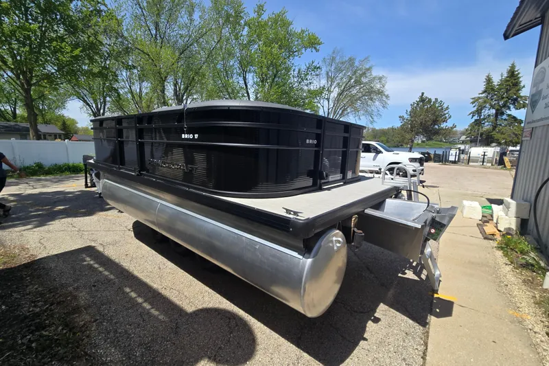 Slide: The Image of 2026 Princecraft Brio 17 Electric pontoon boat parked outdoors on a sunny day. - 2