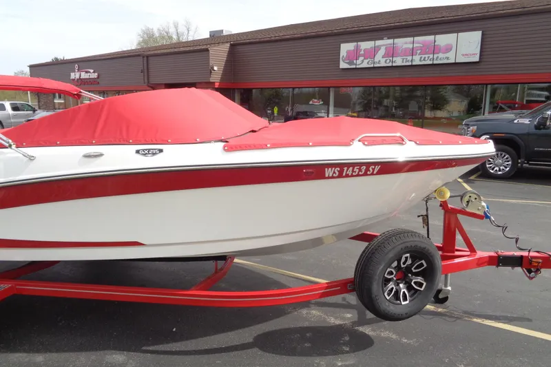 Slide: The Image of 2022 Glastron GX 215 boat with red cover on trailer in parking lot. - 3
