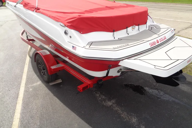 Slide: The Image of 2022 Glastron GX 215 boat with red cover on a trailer, rear view. - 8