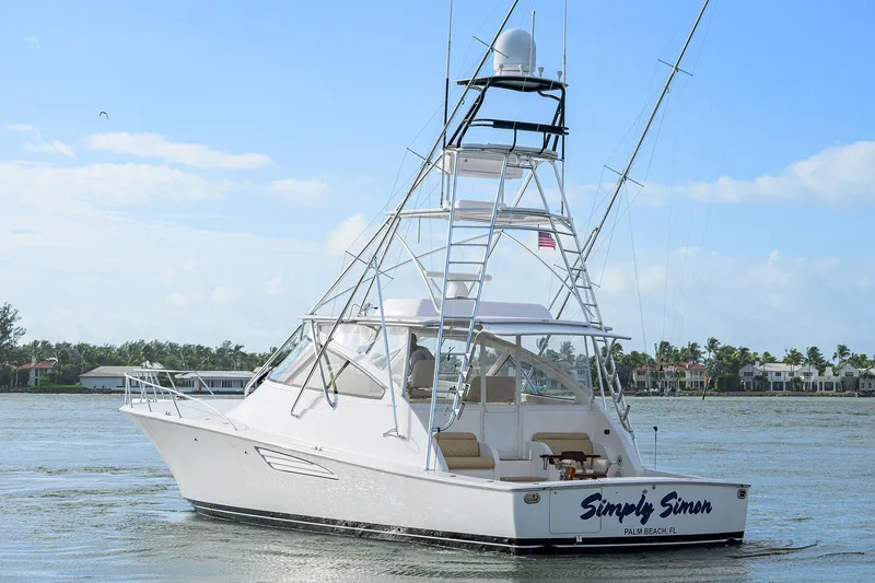 Slide: The Image of 2015 Viking 52 Open yacht on water, featuring a sleek design and tower, labeled "Simply Simon." - 10