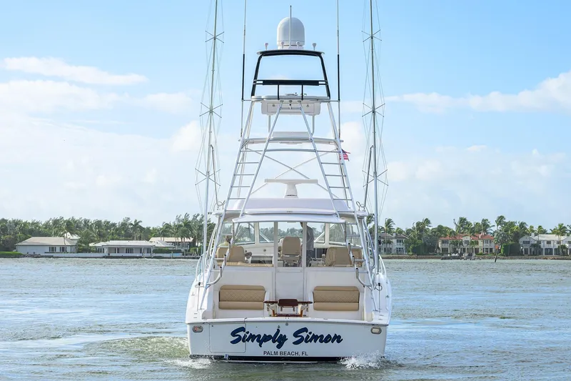 Slide: The Image of 2015 Viking 52 Open yacht on water, rear view, with coastal homes in background. - 11