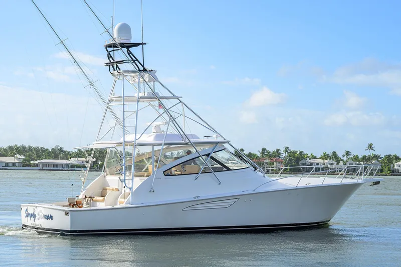 Slide: The Image of 2015 Viking 52 Open yacht cruising on a sunny day near coastal homes. - 13