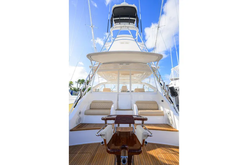 Slide: The Image of 2015 Viking 52 Open yacht with spacious deck and seating, under clear blue sky. - 40