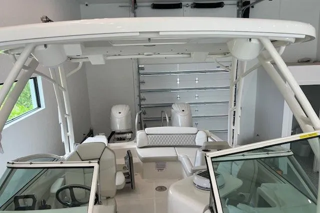 Slide: The Image of 2026 World Cat 230 SD boat interior with seating and helm in a garage. - 10