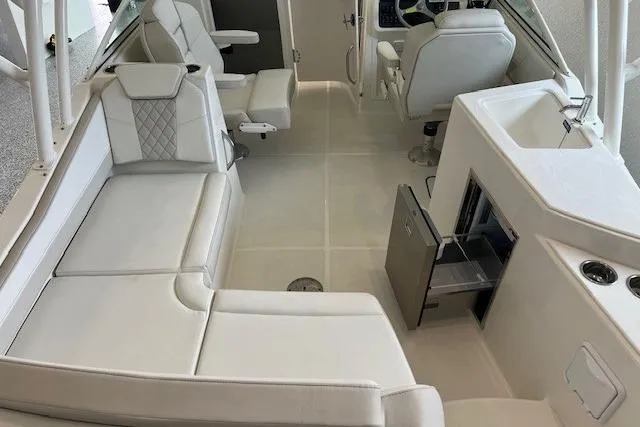 Slide: The Image of Luxurious interior of 2026 World Cat 230 SD boat with white seating and helm. - 12